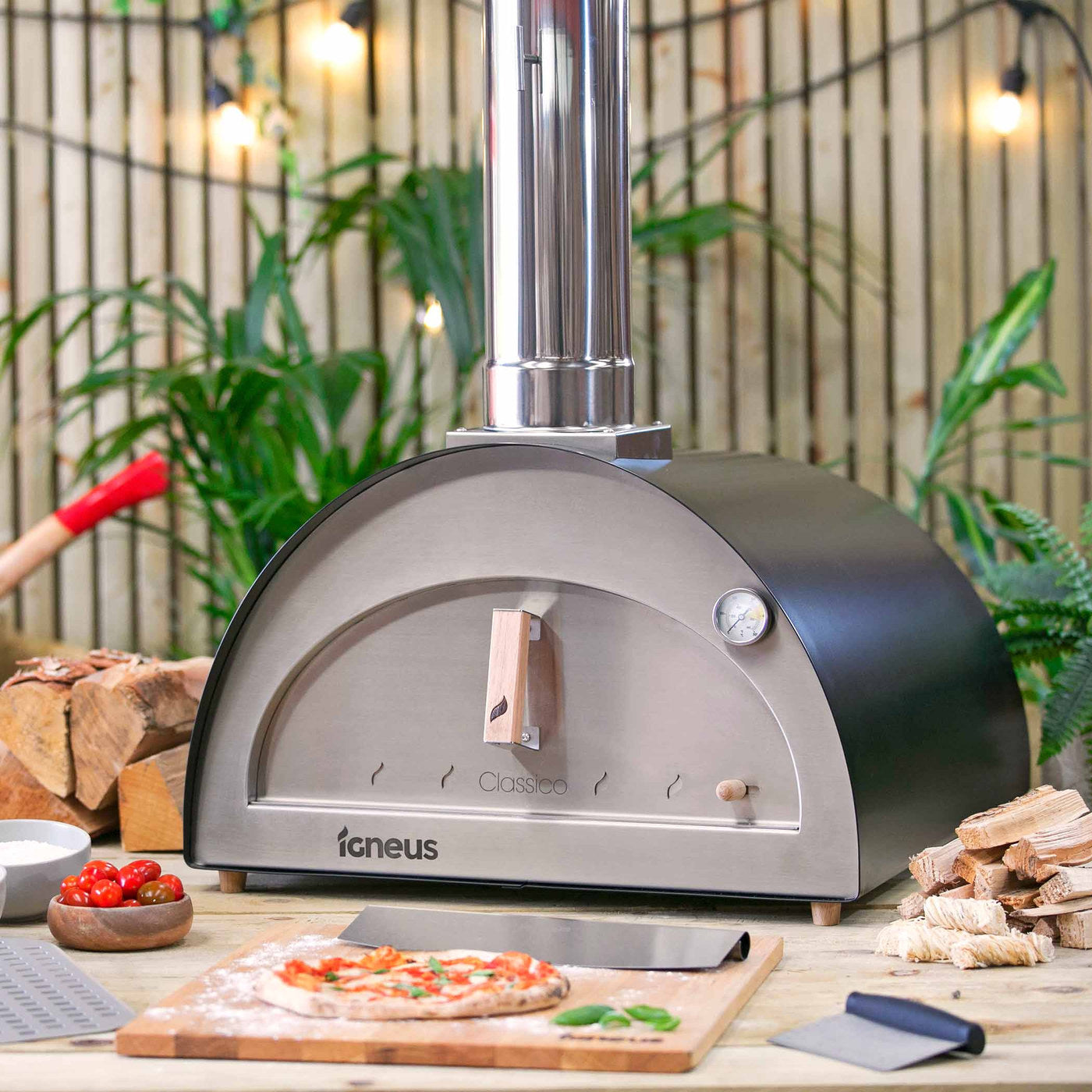 Igneus Classico wood-fired pizza oven in a garden with a freshly cooked pizza