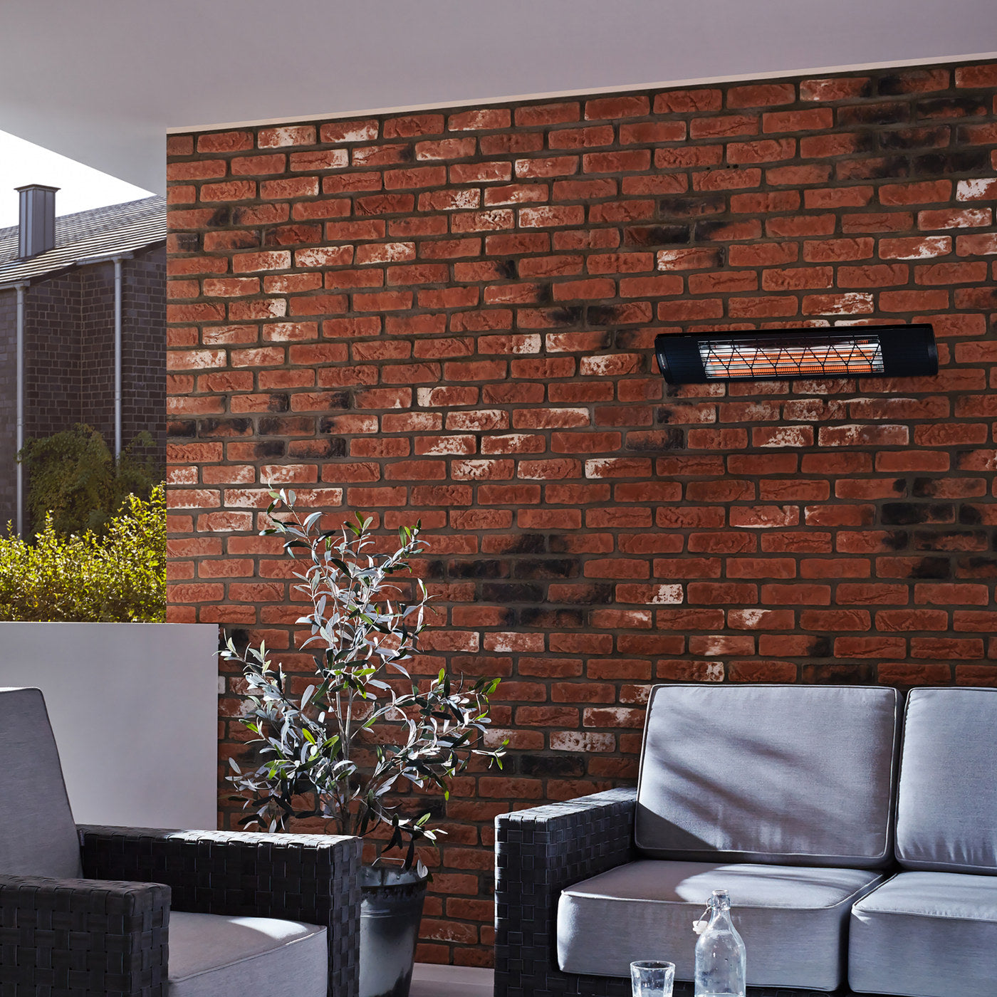 Heatscope Next 3000W electric radiant heater mounted on a brick wall above outdoor seating
